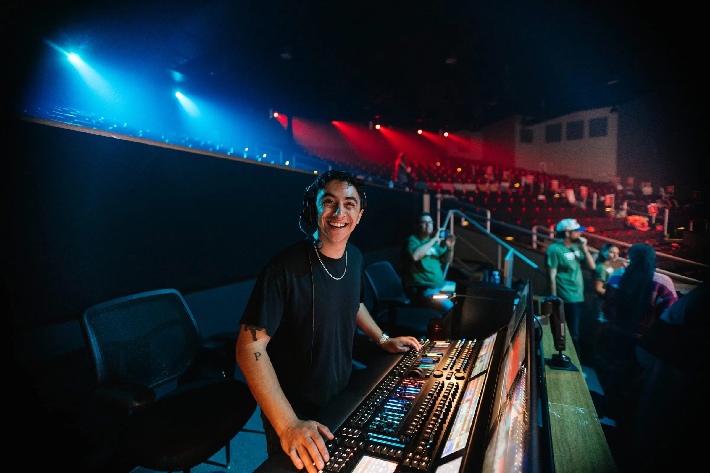 A volunteer runs the sound board from the tech booth overlooking the auditorium.